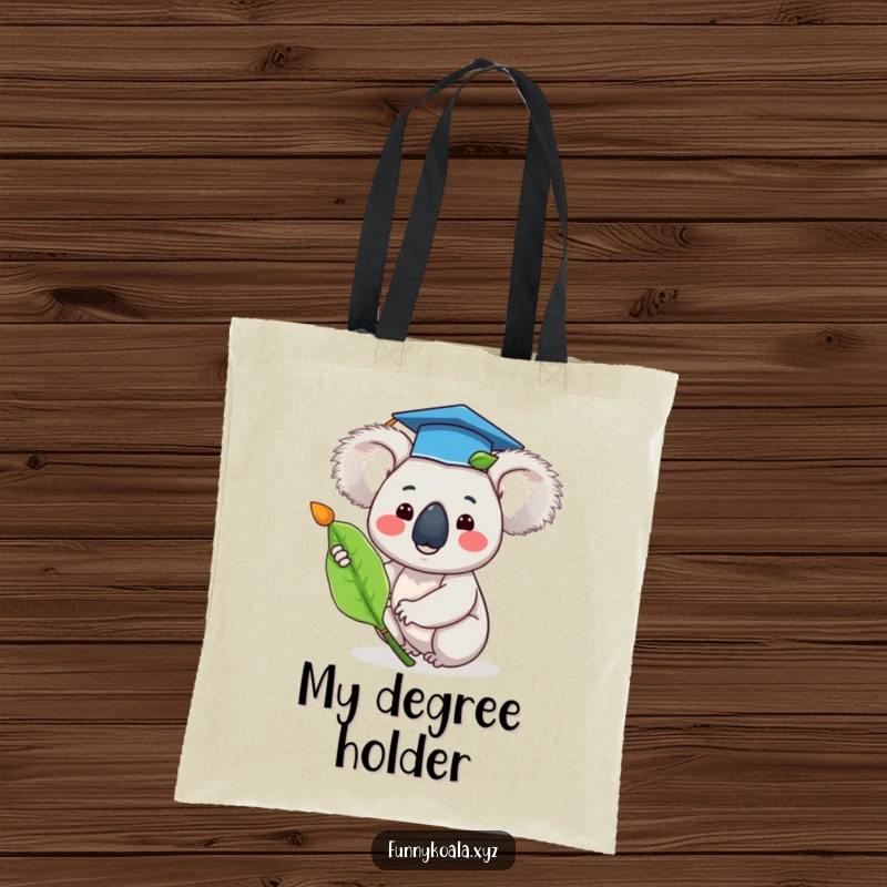 Funny graduation koala tote bag showing a happy koala in a tiny graduation cap waving a eucalyptus leaf, perfect for graduates.